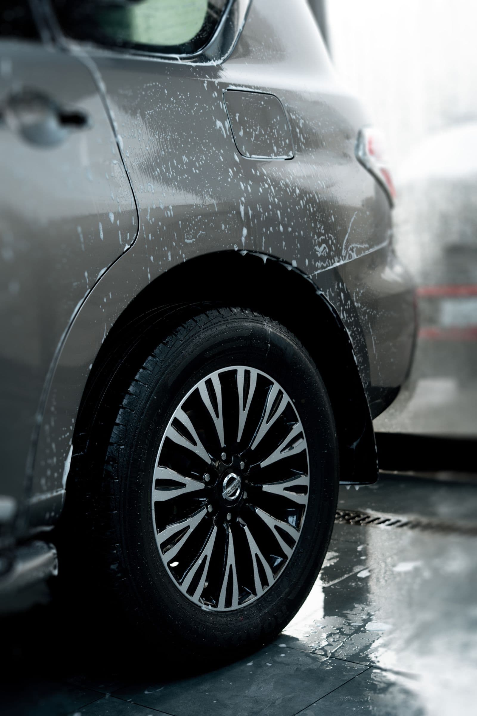 Freshly washed SUV flank with a gleaming polished wheel